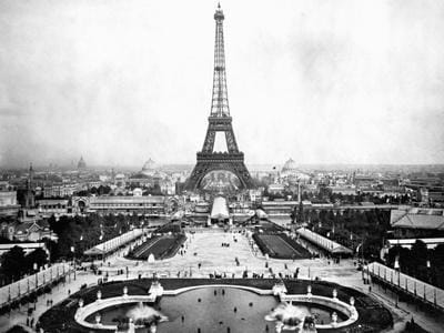 Vintage photograph of the Eiffel Tower at the 1889 Exposition Universelle in Paris, showcasing the tower and surrounding exhibition grounds.
