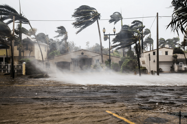 Strong winds and flooding impact a residential area during an extreme weather event linked to climate change.