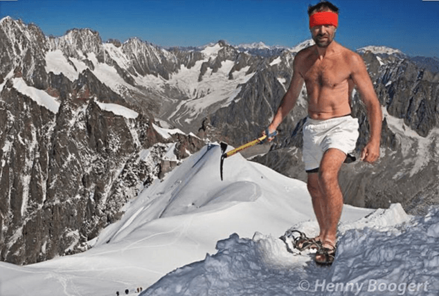 Wim Hof on snowy mountain peak wearing only shorts