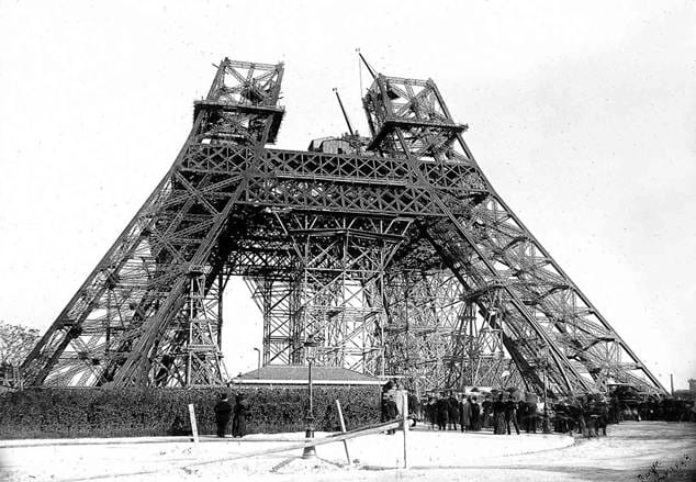 Eiffel Tower under construction in 1888 showing the iron framework and workers at the base