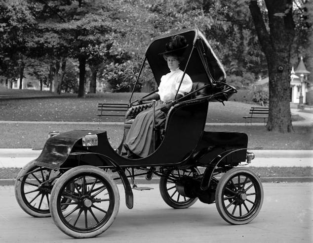 An early 1900s electric carriage-style vehicle showcasing the design of historical electric cars.